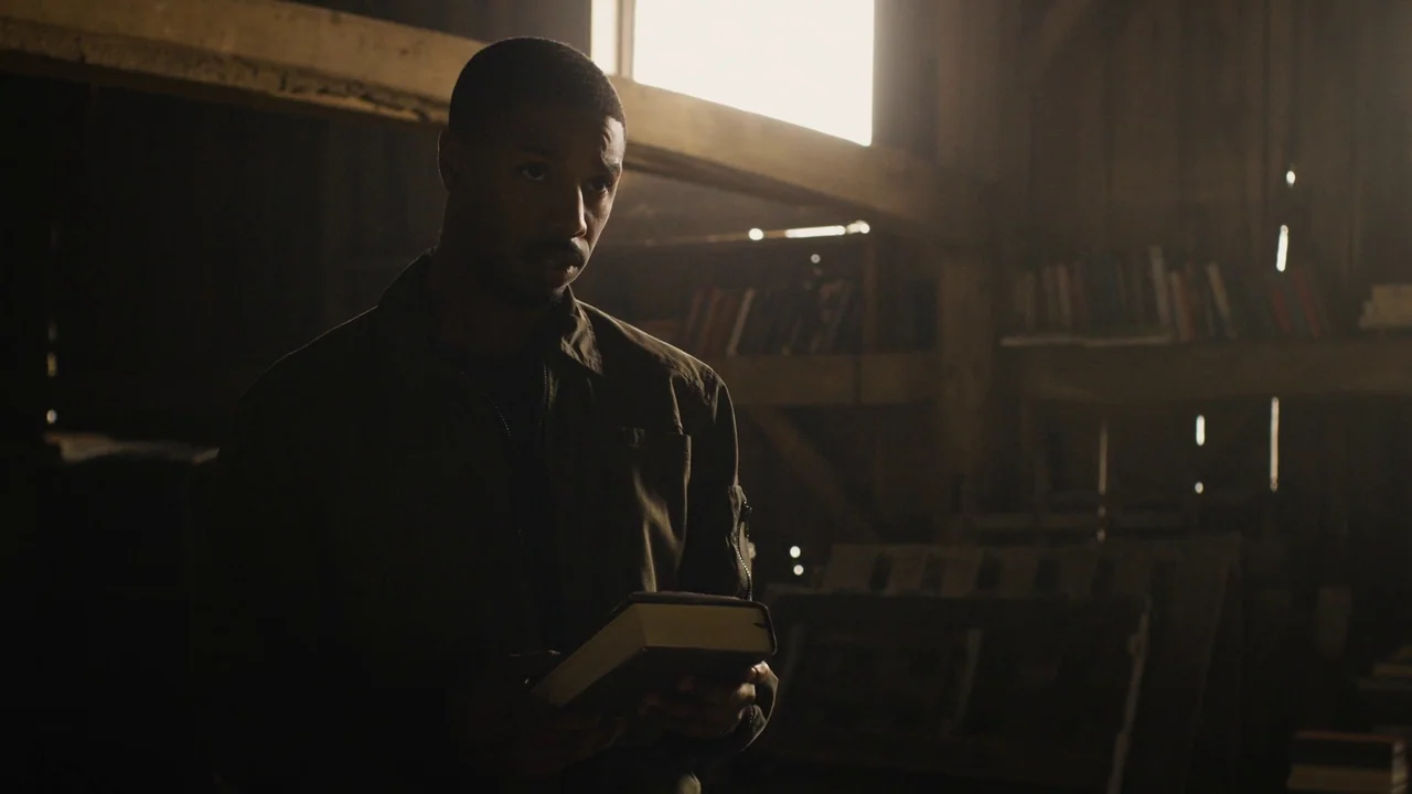 Fahrenheit 451 (2018) (2018) movie still: medium — A dark attic space contains wooden beams and shelves with various items. A man holds a thick book…