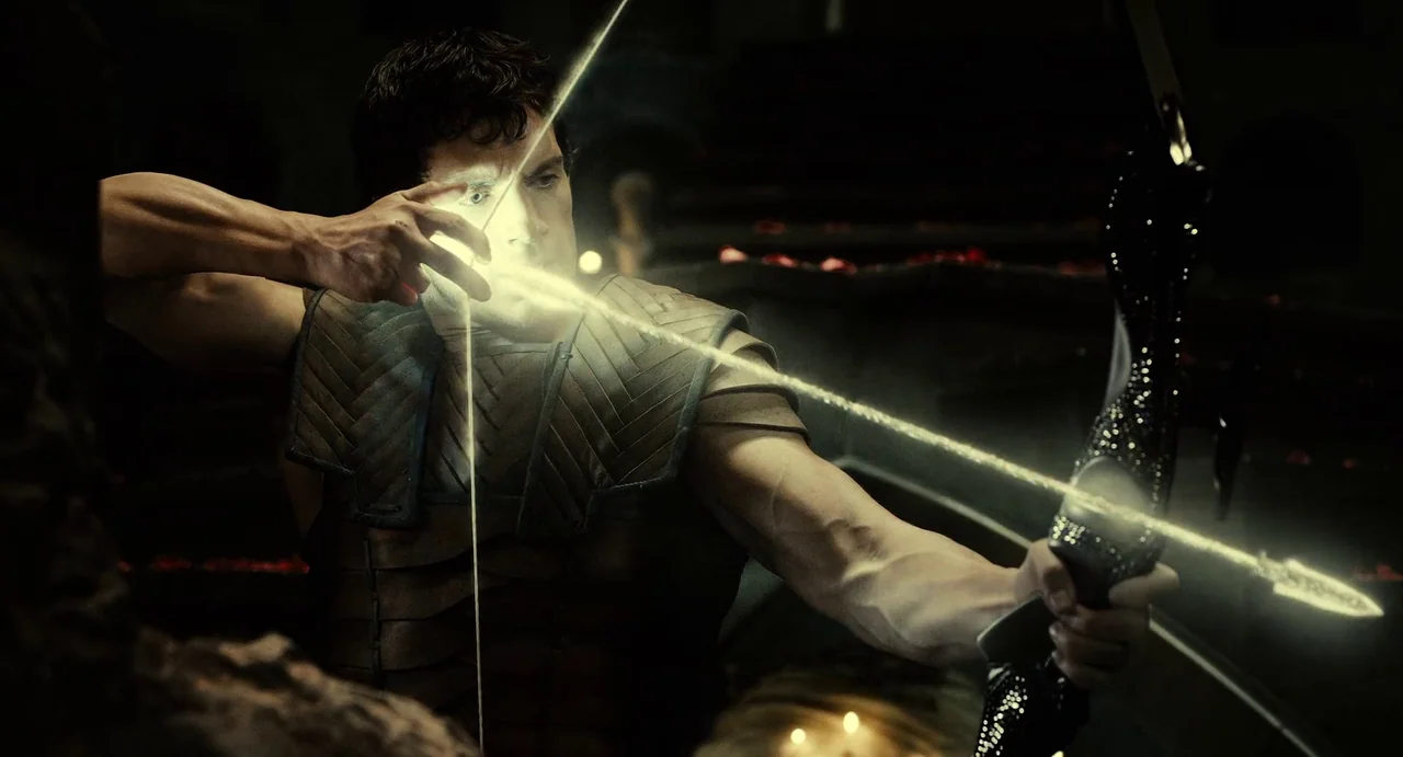 The Immortals (2011) movie still: medium — A darkened interior space features shadowy, cavernous architecture faintly illuminated by scattered light…