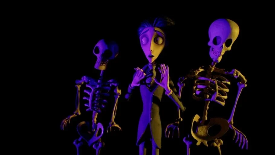 Corpse Bride (2005) movie still: medium — A dark space serves as the backdrop for three stylized figures against black. The central male character…