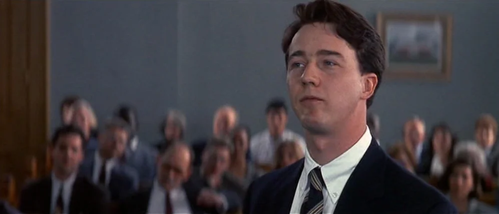 The People vs. Larry Flint (1996) movie still: medium — A formal, dimly-lit courtroom features rows of seated observers in the blurred background. A…