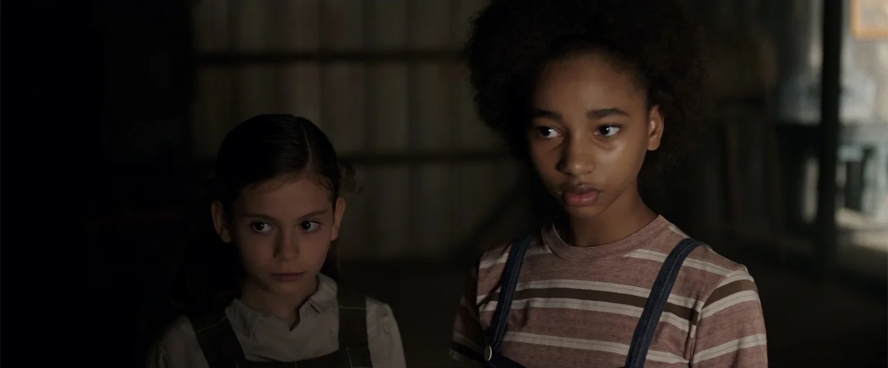 Annabelle: Creation (2017) movie still: medium — A dark, wood-paneled room interior serves as the background for two young girls. The girls stand…