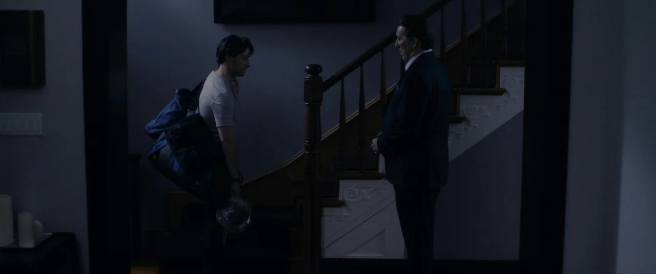 The Disappearance of Eleanor Rigby: Him (2014) movie still: fullbody — A dark, modern foyer features a wooden staircase with white detailing against…