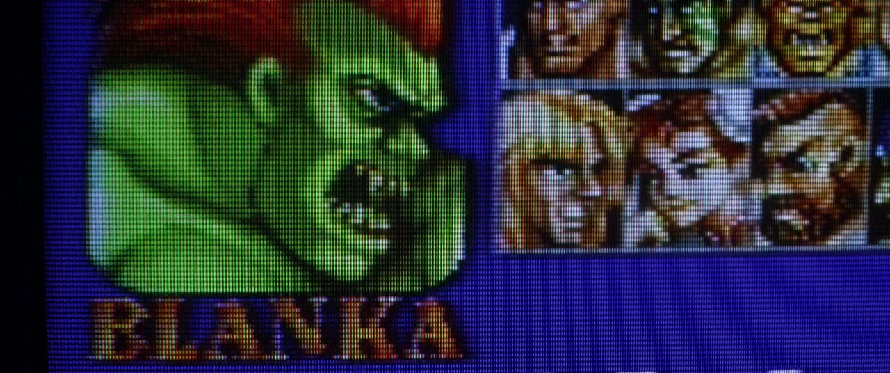 Kings Of Summer (2013) movie still: closeup — A close-up view of a 16-bit video game character selection screen on a monitor. The green-skinned…