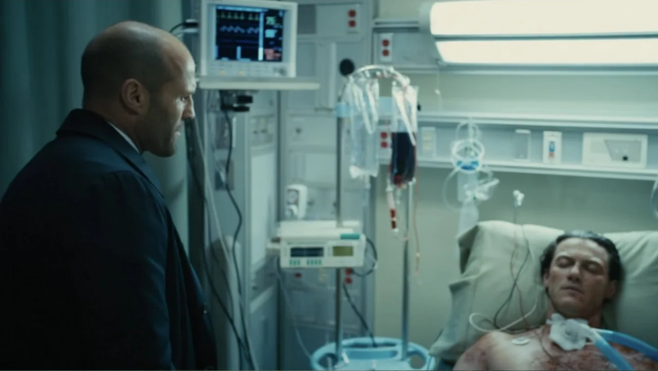 Furious 7 (2015) movie still: medium — A sterile medical unit features white wall panels, medical monitors, and intravenous drip stands. A man…