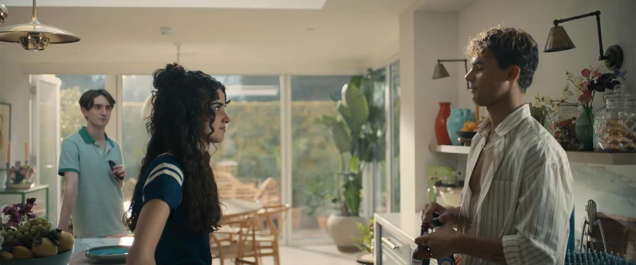My Fault: London (2025) movie still: medium — A bright open-plan space with large windows overlooking a garden area. A young woman and a young man…