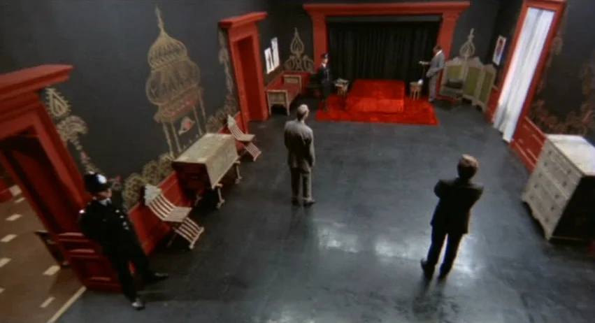 A Lizard In A Woman’s Skin (1971) movie still: wide — A spacious room features matte black walls decorated with ornate, gold-painted Indian…