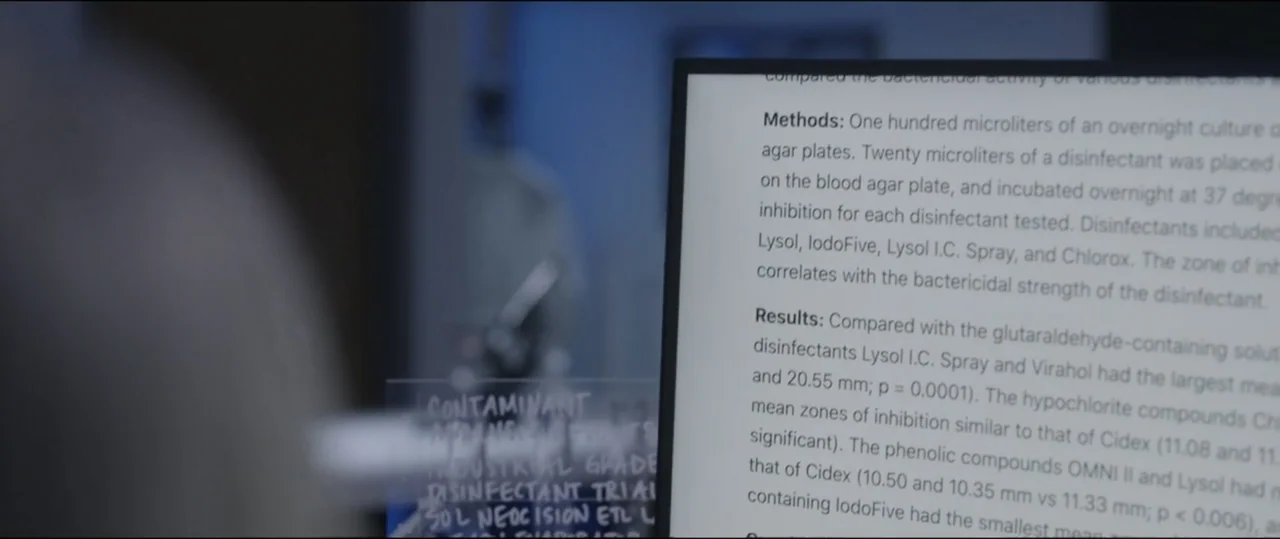 Summer Camp (2024) movie still: closeup — A laboratory setting features a computer screen displaying a scientific document about disinfectant…