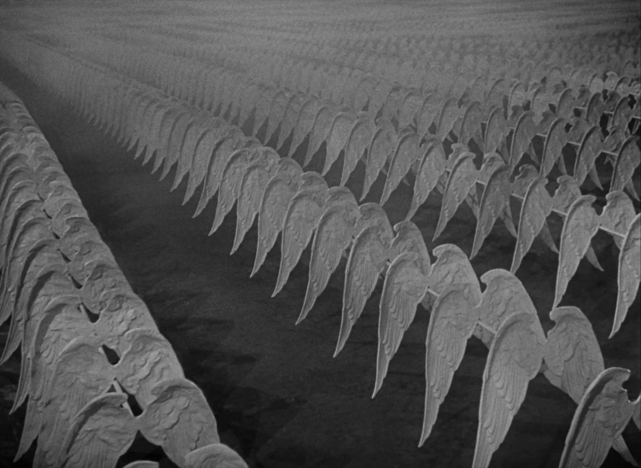 A Matter of Life and Death (1946) movie still: A haunting, monochromatic expanse filled with endless rows of white angel wings stretching toward an…