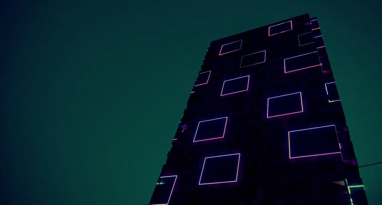 Rabid (2019) movie still: establishing — A modern skyscraper facade rises vertically against a dark, featureless night sky background. Several…