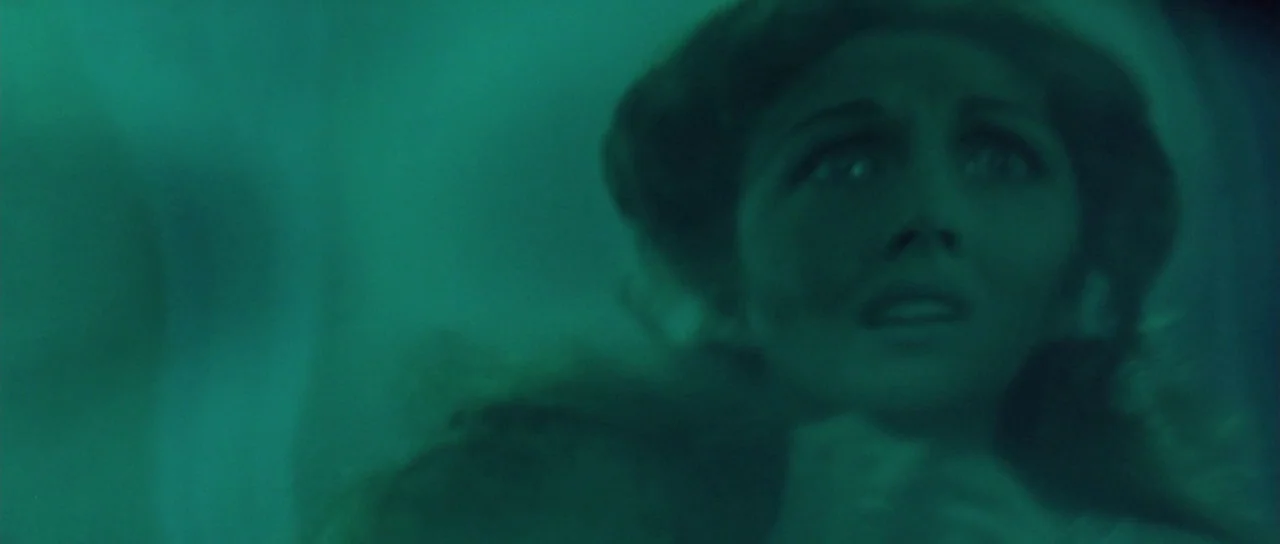 The Masque of the Red Death (1964) movie still: closeup — A woman's face is seen submerged in murky green water. She looks directly forward with…