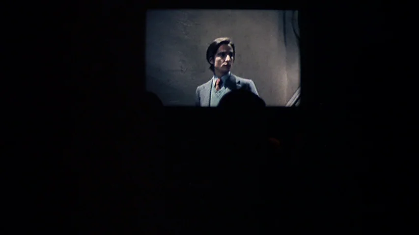 Day for Night (1973) movie still: wide — A dark movie theater interior shows a bright rectangular projection screen in the distance. The screen…