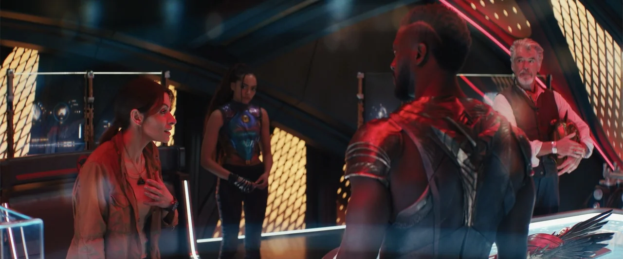 Black Adam (2022) movie still: medium — A dark command room with glowing neon panels and integrated displays in the walls. A woman interacts with an…