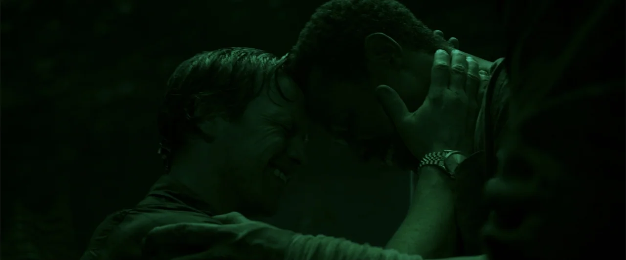 K.G.F: Chapter 2 (2022) movie still: medium — Two men stand face to face in a dark, poorly lit indoor environment. They press their heads together…