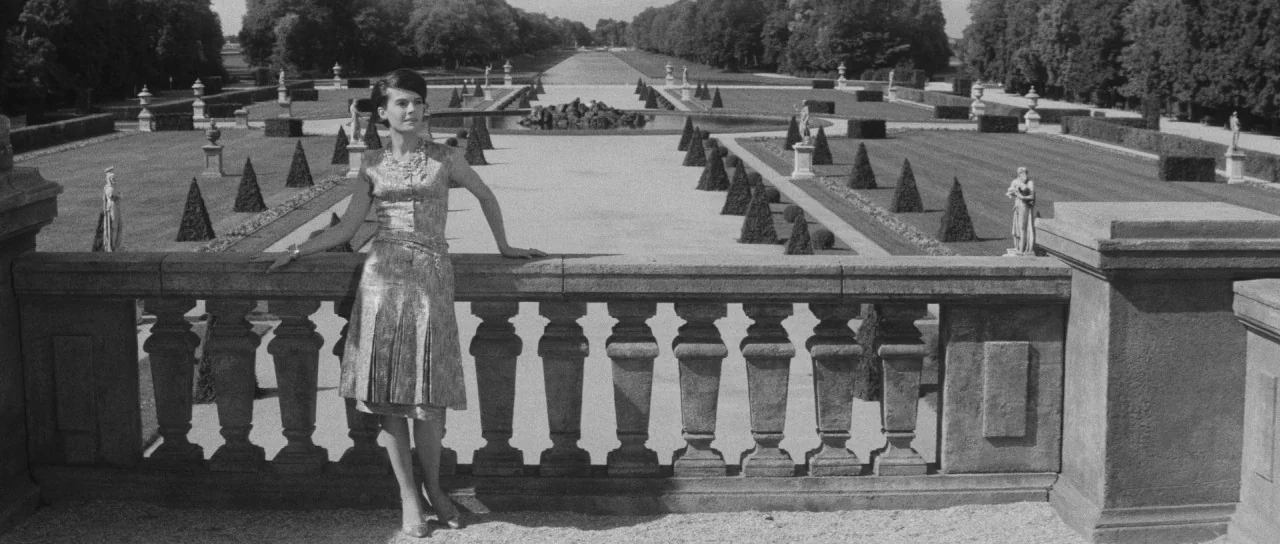 Last Year at Marienbad (1961) movie still: fullbody — A vast, meticulously manicured French formal garden features symmetrical paths and trimmed…