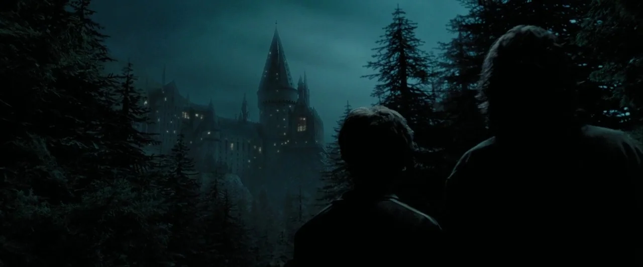 Harry Potter and the Prisoner of Azkaban (2004) movie still: wide — A dark, wooded landscape at night surrounds a large stone castle in the…