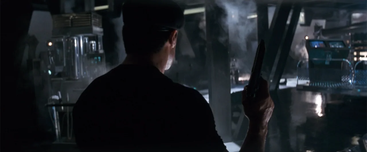 Demolition Man (1993) movie still: medium — A dark, high-tech industrial space features complex metallic structures and glowing electronic…