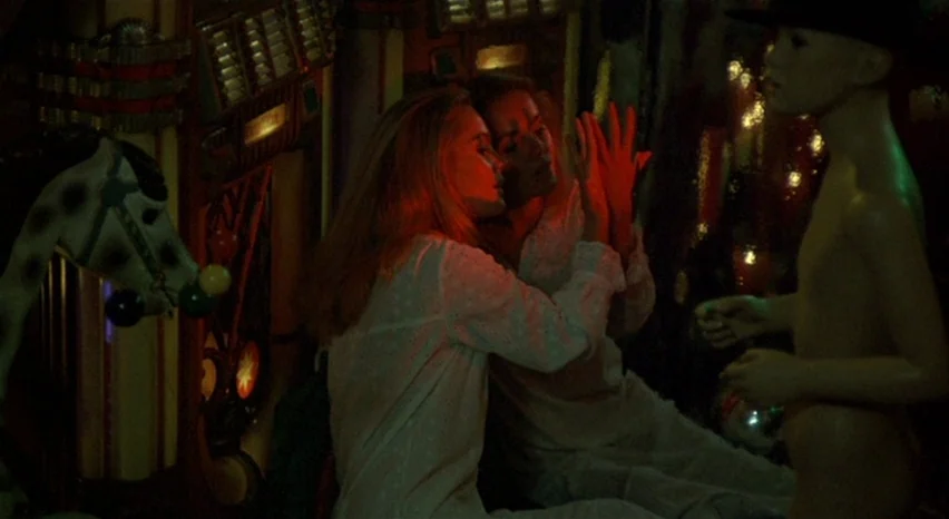 A Safe Place (1971) movie still: medium — Two women in white nightgowns sit in a dimly lit room with vintage decorations. They face each other and…