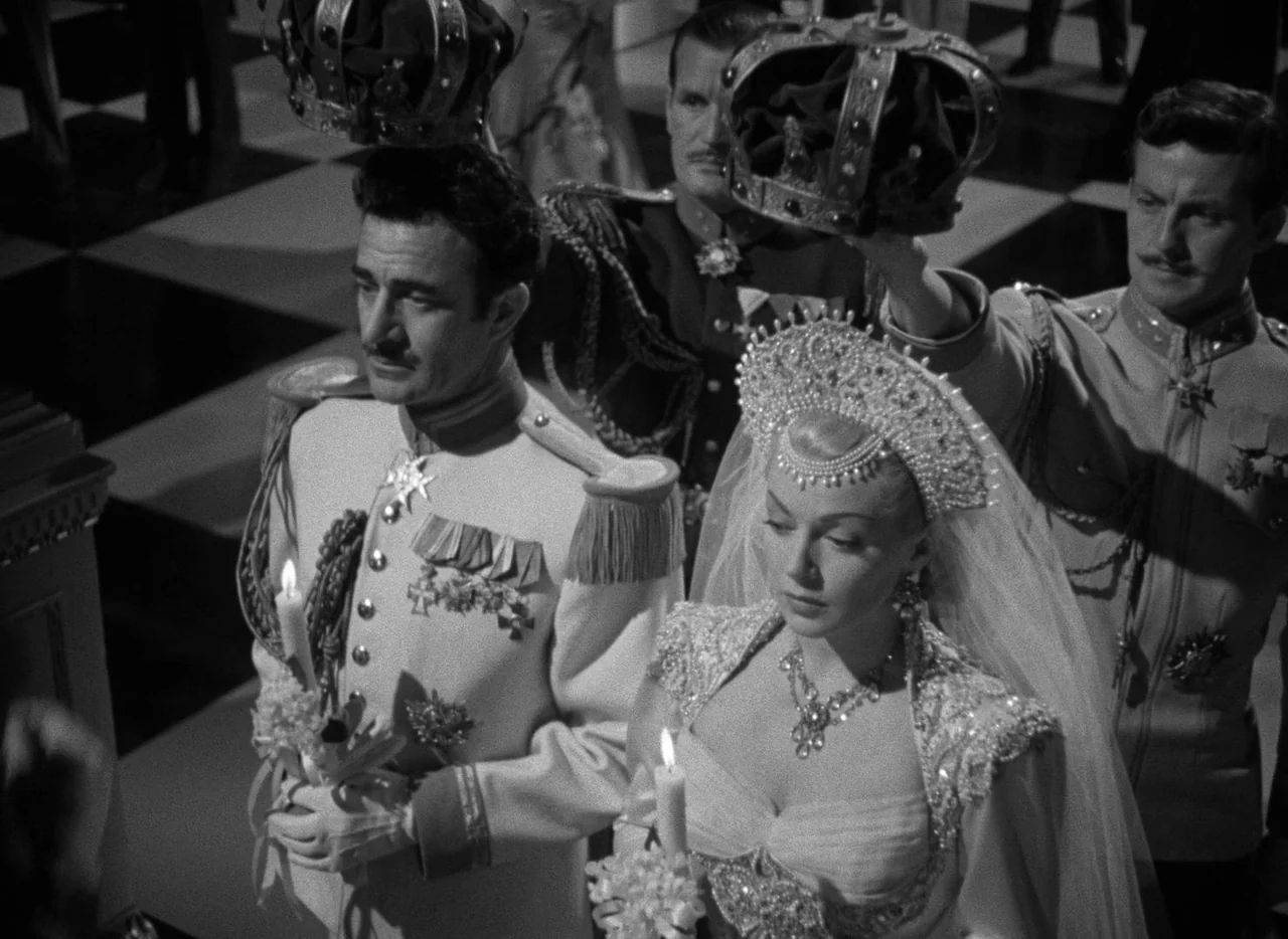 The Bad and the Beautiful (1952) movie still: medium — A formal wedding occurs in a grand, checkerboard-floored hall with crown-bearing attendants…