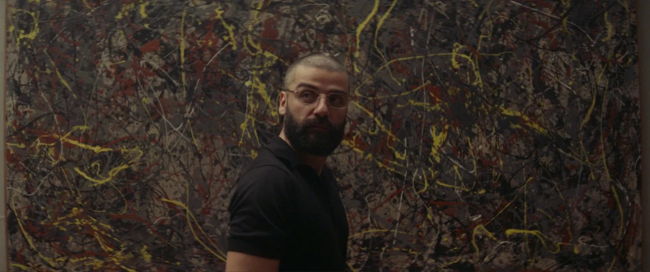 Ex Machina (2015) movie still: medium — A man stands before a large abstract expressionist painting with thick black, yellow, and red splatters. The…