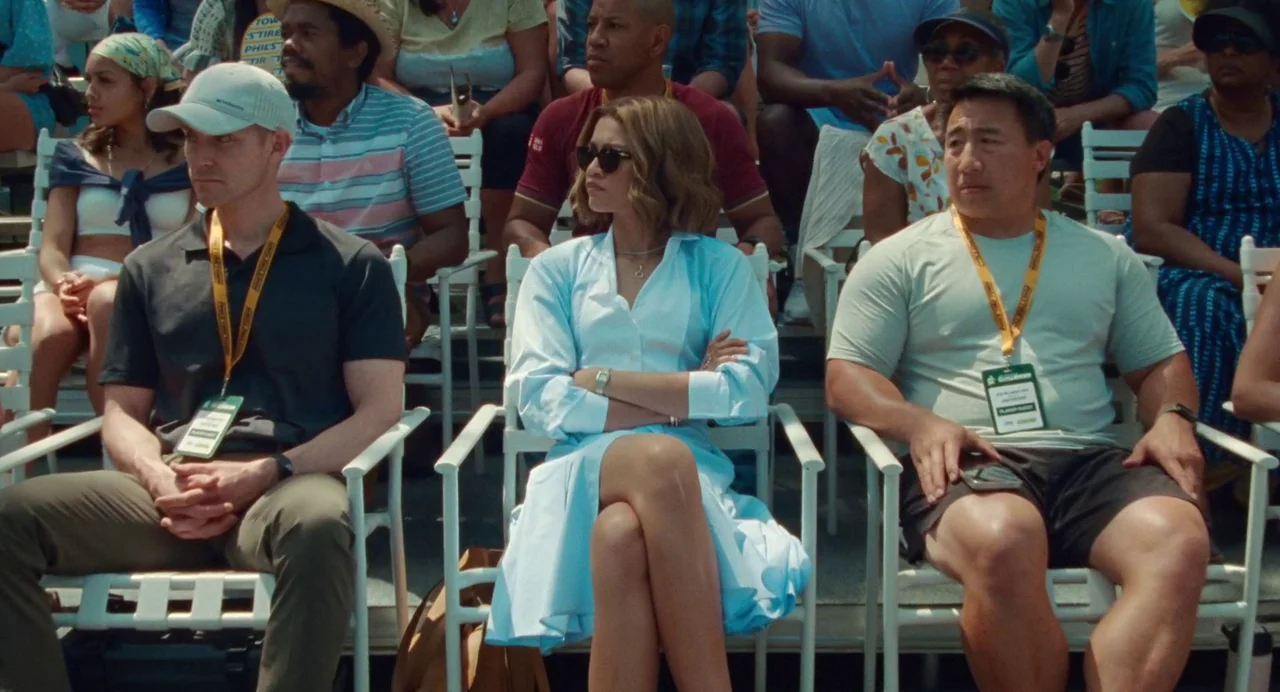 Challengers (2024) movie still: medium — A rows of white plastic spectator chairs are filled with people at an event. A woman sits in the center…