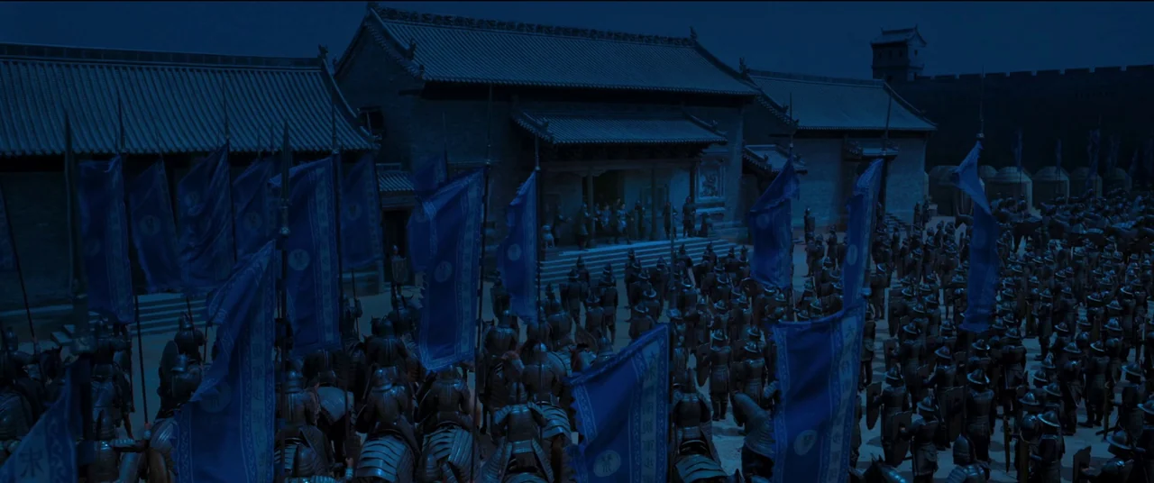 Full River Red (2023) movie still: establishing — A sprawling military encampment with stone buildings at night under moonlight. A large group of…