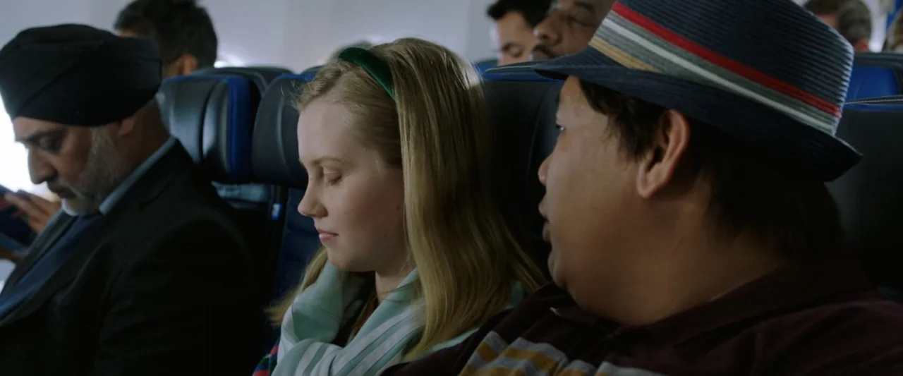 Spider-Man: Far From Home (2019) movie still: medium — An airplane cabin with dark blue upholstered headrests and rows of passenger seats. Three…