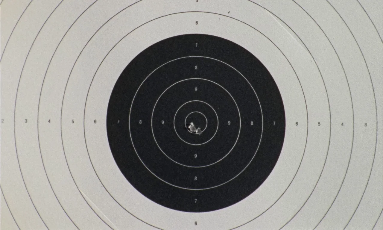 Thriller: A Cruel Picture (1973) movie still: closeup — A paper shooting target with concentric circles and printed numbers rests on a flat surface.…