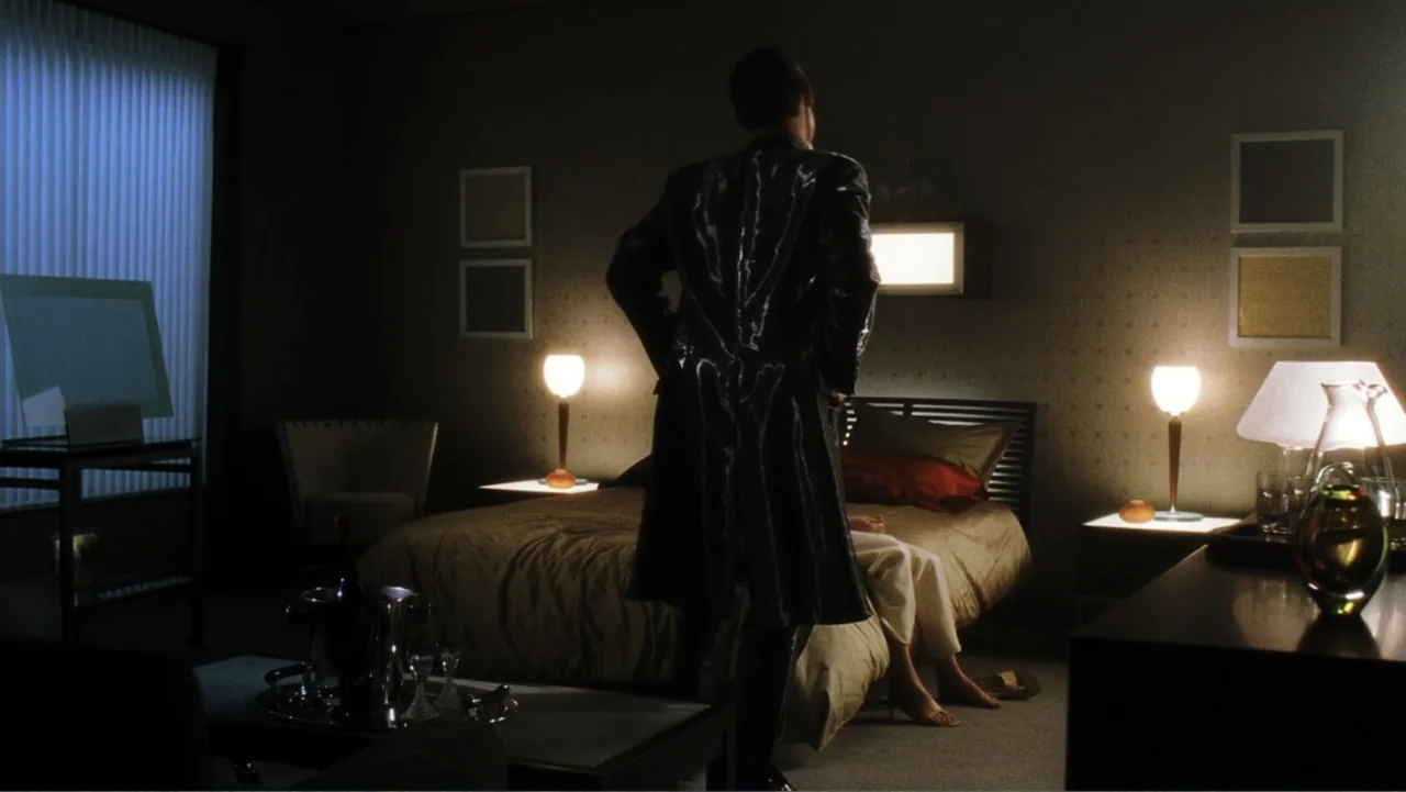 A.I. Artificial Intelligence (2001) movie still: medium — A dimly lit hotel room features patterned wallpaper and multiple small bedside table…