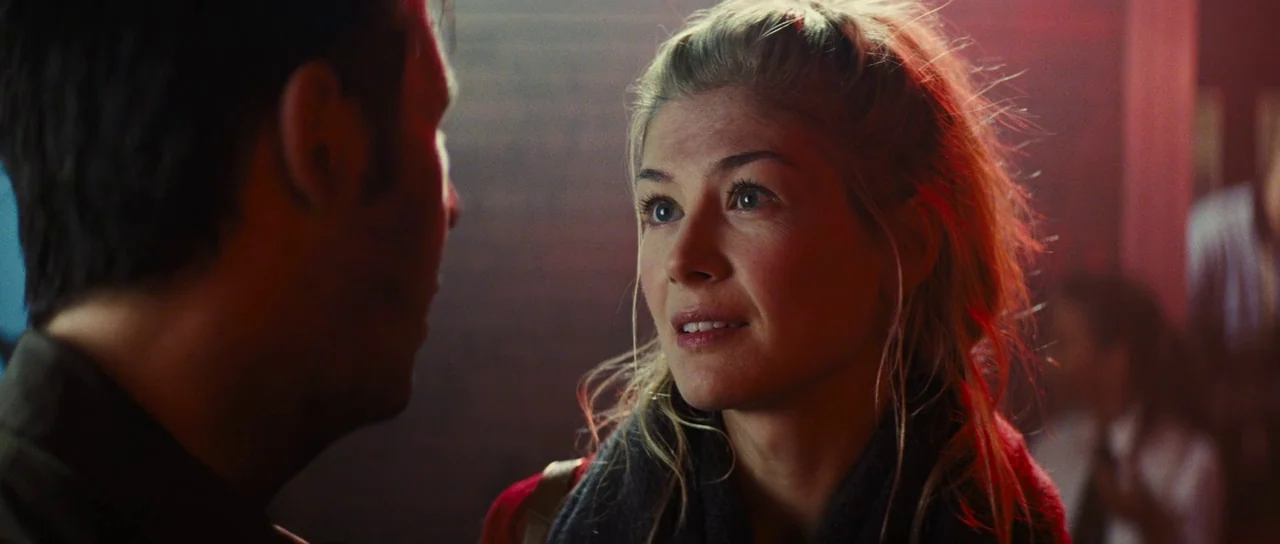 The World’s End (2013) movie still: closeup — A dimly lit interior space with red neon accents reflecting on a person. A blonde woman talks to a man…
