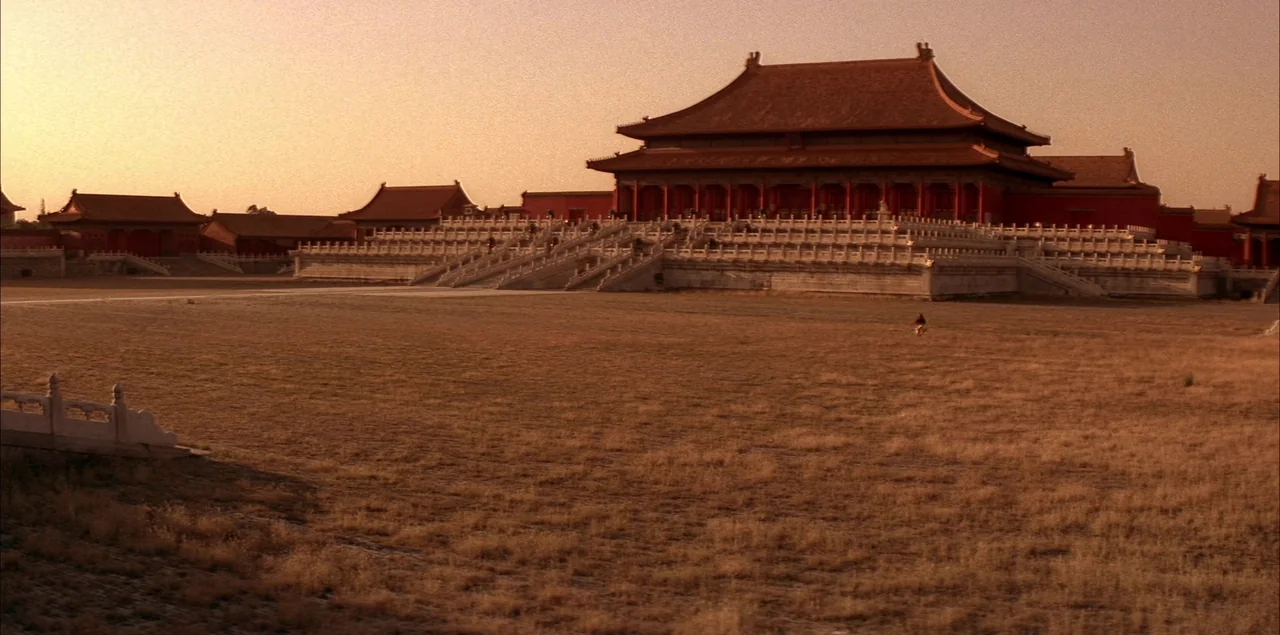 The Last Emperor (1987) movie still: wide — A wide view of a large, dry-grass courtyard framed by traditional Chinese palace structures.…
