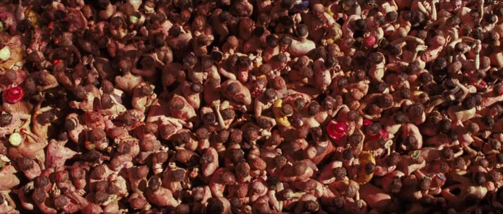 We Need To Talk About Kevin (2011) movie still: wide — A high-angle view captures a massive, densely packed crowd of people standing tightly…