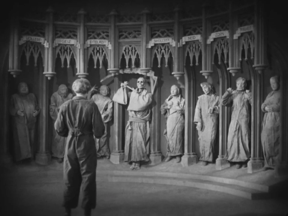Metropolis (1927) movie still: fullbody — An interior space features arched alcoves displaying statues representing human sins under gothic arches.…