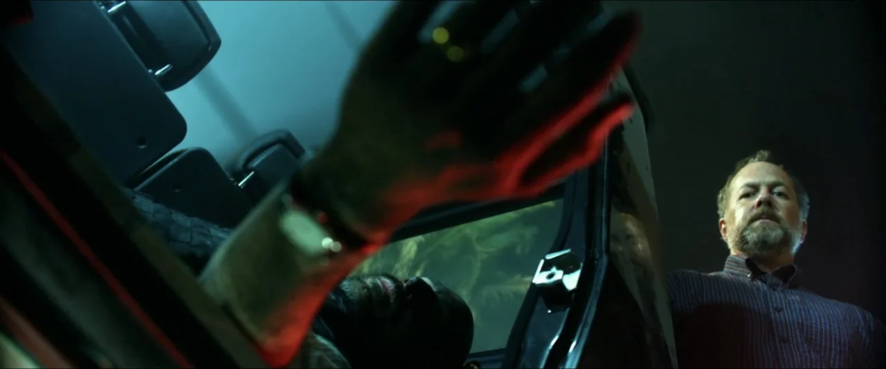 13 Hours: The Secret Soldiers of Benghazi (2016) movie still: medium — A dark vehicle interior with a man looking towards a foreground hand in…