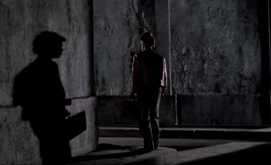 Mauvais Sang (Bad Blood) (The Night Is Young) (1986) movie still: medium — An outdoor urban corner features textured concrete walls illuminated by a…