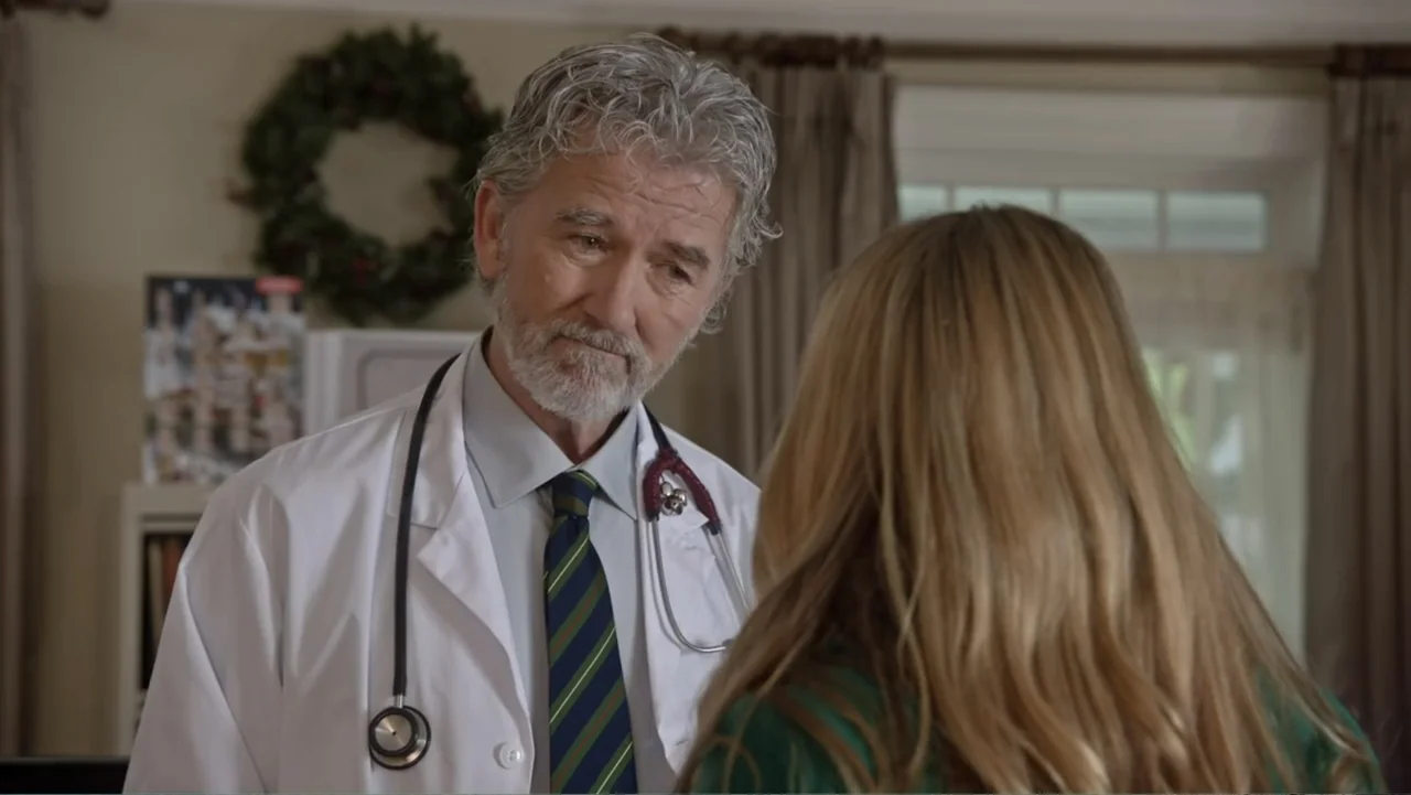 The Christmas Cure (2017) movie still: medium — An interior space features a medical professional speaking with a patient in a room. A doctor stands…