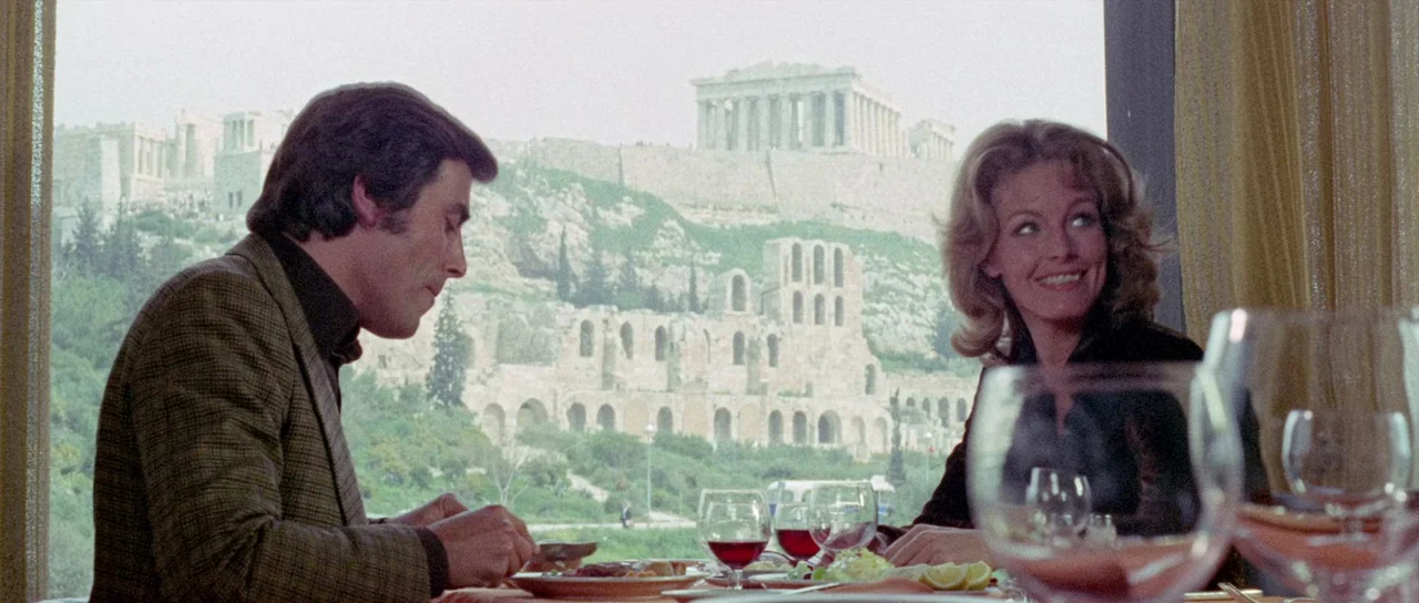 The Case of the Scorpion’s Tail (1971) movie still: medium — A restaurant interior with a large window overlooking an ancient hillside of stone…