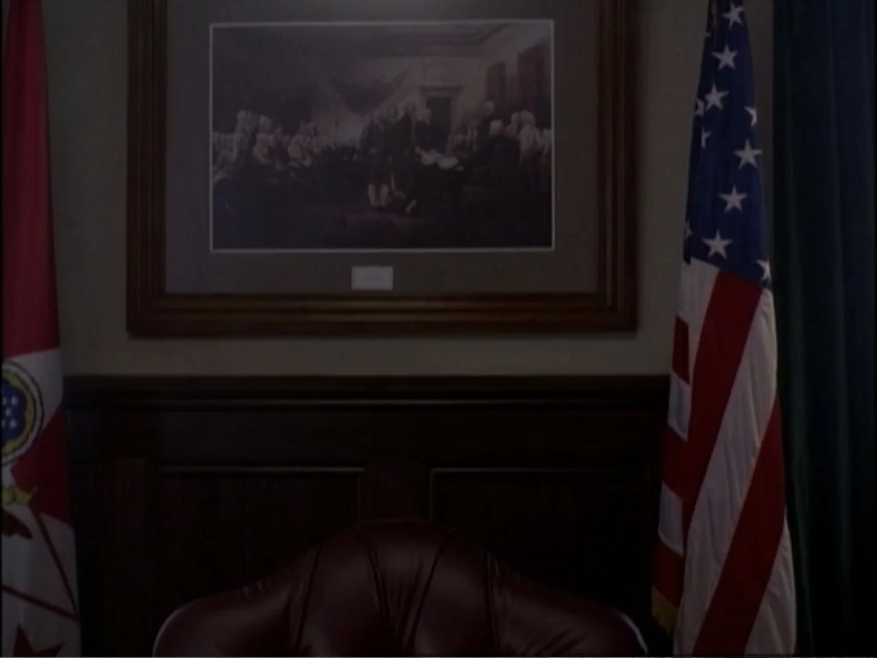 In Pursuit of Honor (1995) movie still: medium — A dark wooden office interior features a leather chair positioned below a framed print. Two tall…