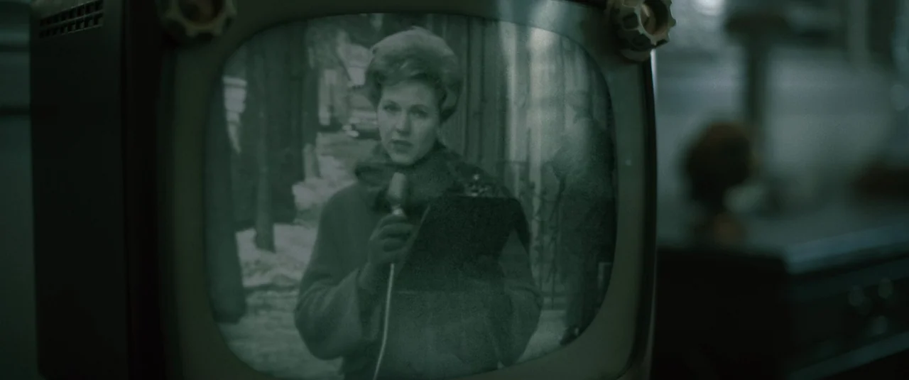 Boston Strangler (2023) movie still: medium — A close view of a vintage television screen displaying a woman outdoors. The woman holds a microphone…