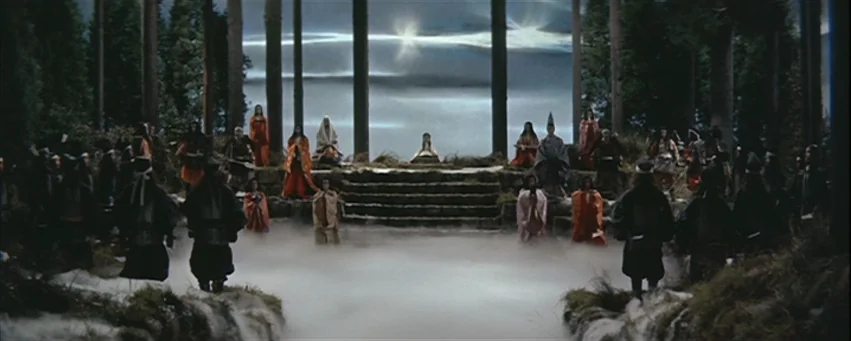 Kwaidan (1964) movie still: wide — A dark, misty forest clearing features a tiered stone dais under a bright sky. A large group of people in…