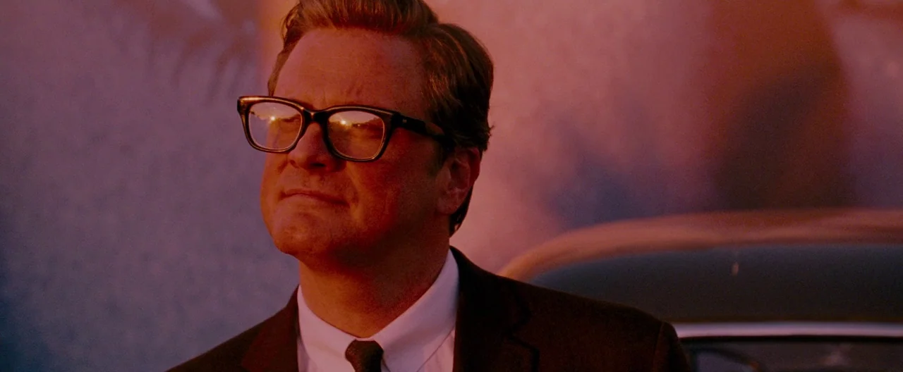A Single Man (2009) movie still: closeup — A man stands outdoors bathed in warm, intense sunset light during golden hour. He looks toward the side…