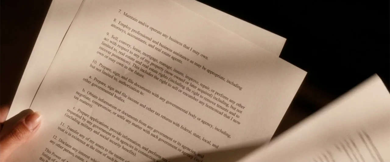 My Sister's Keeper (2023) movie still: closeup — A close-up view of printed legal text on off-white paper. A person's hand holds the documents while…