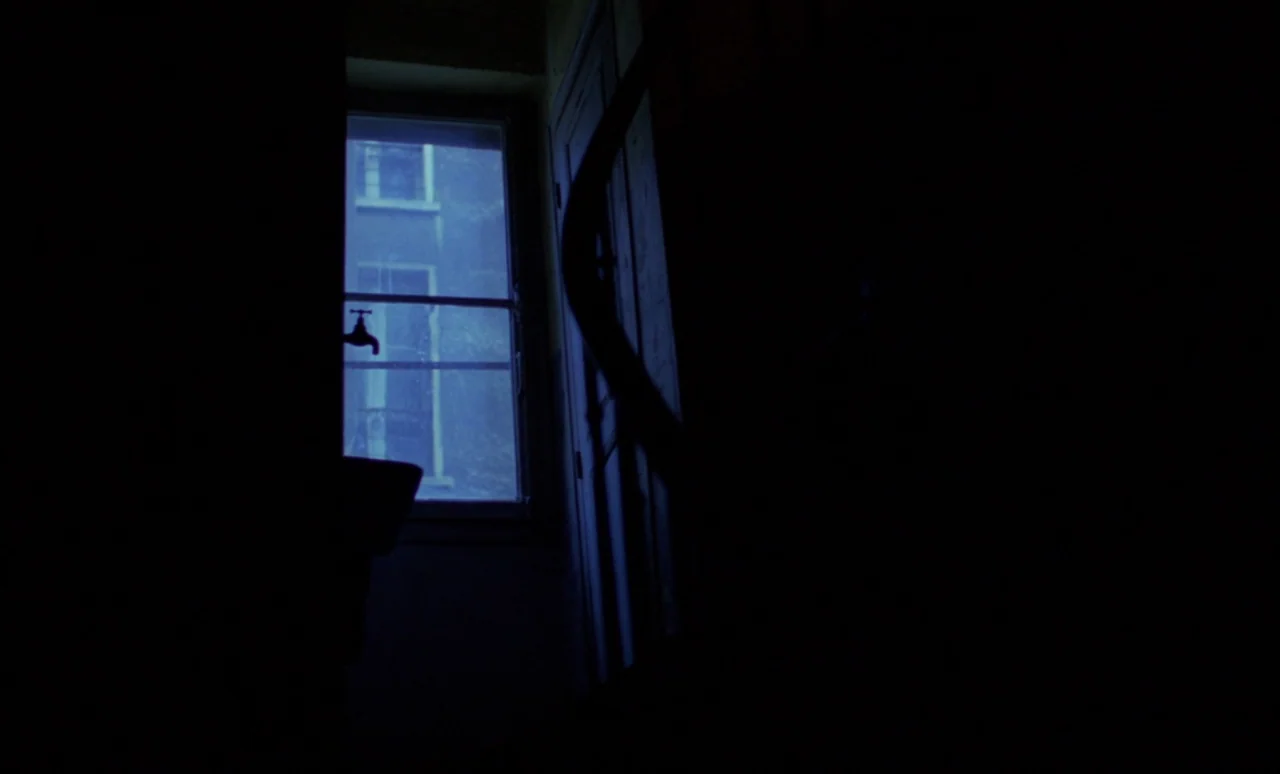 The Strange Case of Dr. Jekyll and Miss Osbourne (1981) movie still: wide — A dark, spartan bathroom interior is visible at night. A single window…