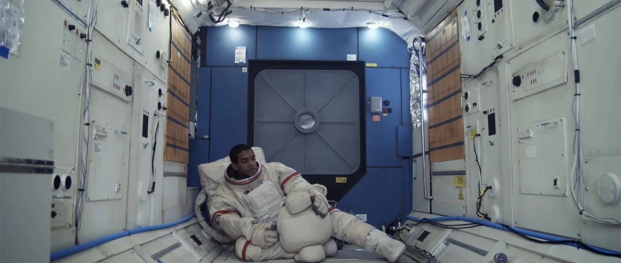 Astronaut: The Last Push (2012) movie still: medium — The interior of a cramped spacecraft module features white modular panels and a hatch. An…