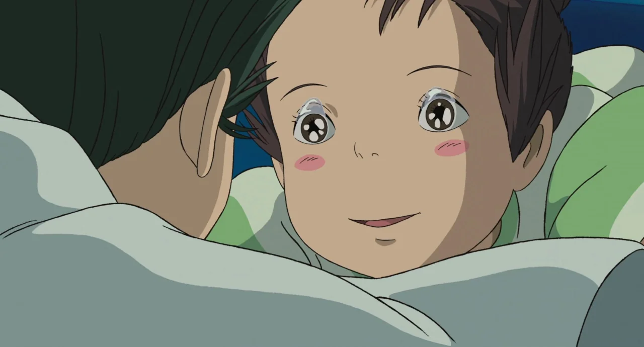Spirited Away (2001) movie still: closeup — A character embraces a small child in a dimly lit, soft-toned space. The child looks toward the camera…
