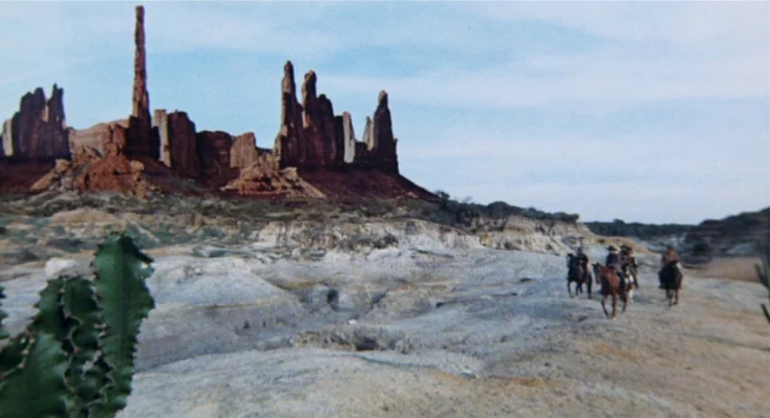 Roy Colt and Winchester Jack (1970) movie still: wide — A vast desert expanse features dramatic eroded red rock formations against a light sky. A…