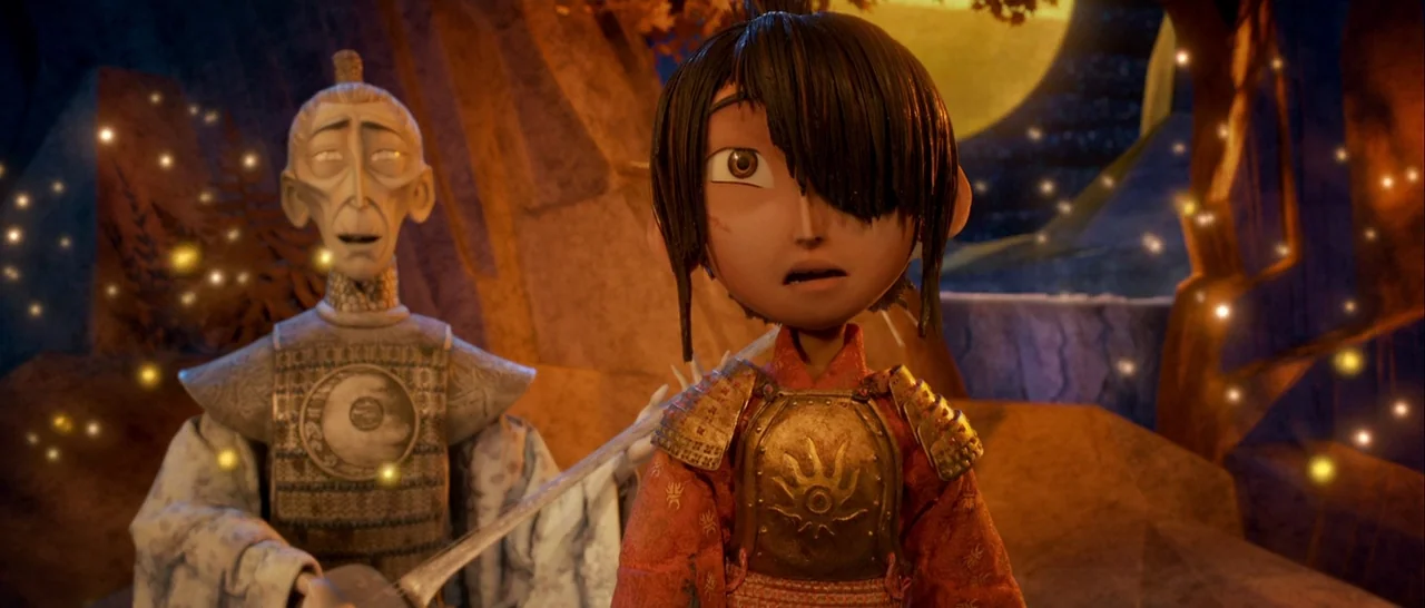 Kubo and the Two Strings movie still: medium — Two figures stand together at night in a rocky, barren area illuminated by floating lights. A young…