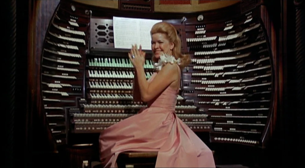 The King Of Marvin Gardens movie still: medium — A woman sits before the intricate, curved console of a multi-manual pipe organ. The massive…