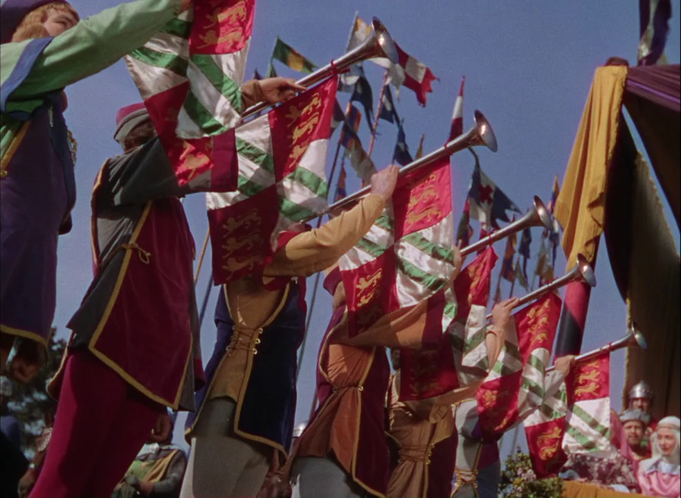 The Adventures of Robin Hood (1938) movie still: medium — A group of medieval trumpeters stand in line at an outdoor tournament. They hold banners…