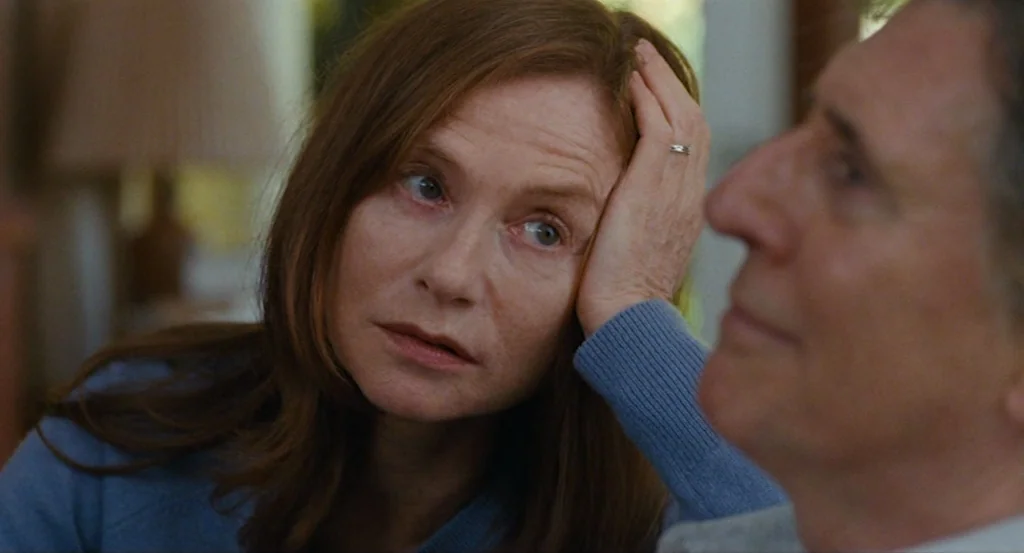 Louder Than Bombs (2015) movie still: closeup — A quiet indoor setting with soft focus on background elements like a lamp. A woman gazes at a man…