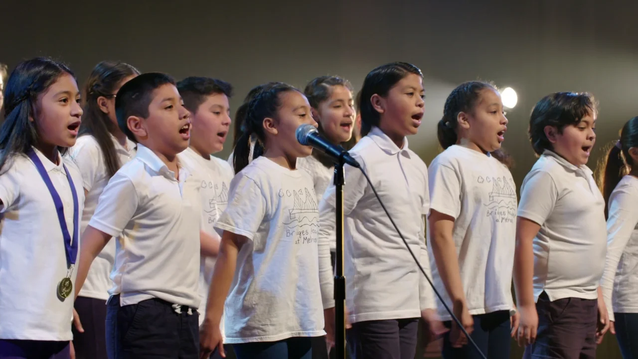 We Are the Dream: The Kids of the Oakland MLK Oratorical Fest (2020) movie still: medium — A group of children stand on a darkened stage with a…